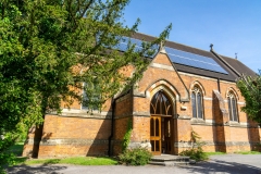 The side entrance of the church. Solar panels are visible on the roof.